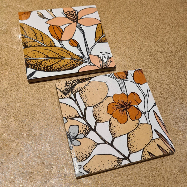Limited-edition set of two handmade 70s floral ceramic coasters in mocha brown and burnt orange.