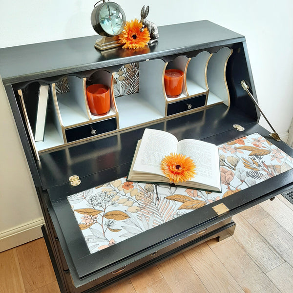 70s mocha and orange wallpaper used in interior of black writing bureau.