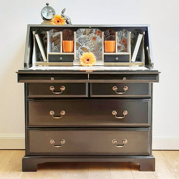 70s mocha orange wallpaper decoupaged inside a black writing bureau.