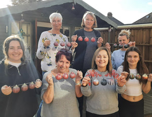 A group of smiling baublers showing off their handmade creations