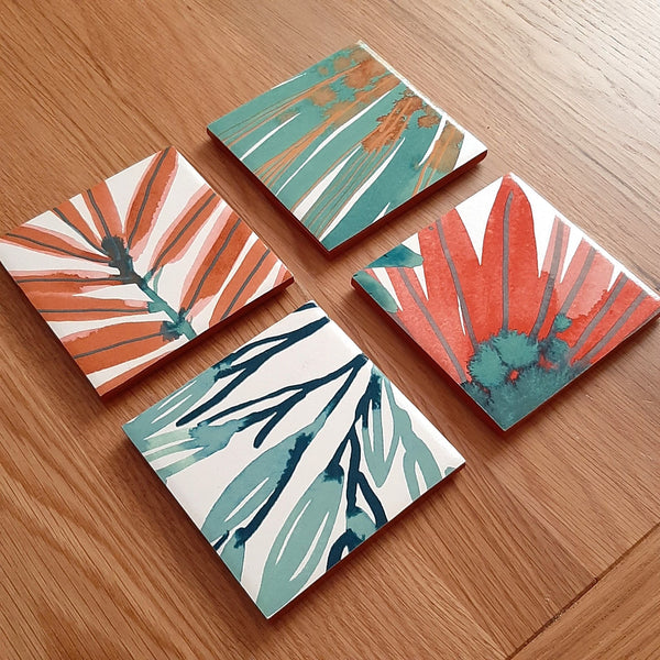 colourful custom made coffee table coasters made using customer's own harlequin yasuni wallpaper, painted with gold edges.