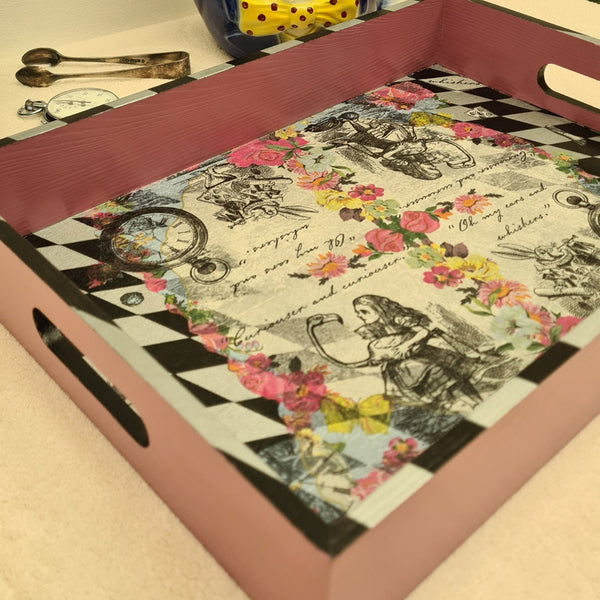 Close-up of hand-painted black and metallic silver harlequin detailing on an Alice in Wonderland serving tray.