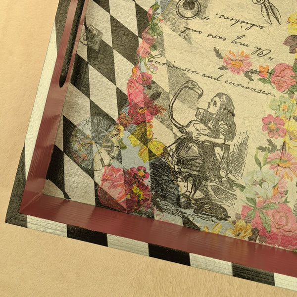 Close-up of hand-painted black and metallic silver harlequin detailing on an Alice in Wonderland serving tray.
