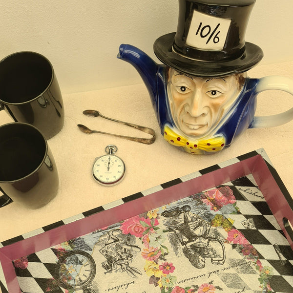 Alice in Wonderland serving tray styled on a coffee table with White Rabbit pocket watch and Mad Hatter teapot.