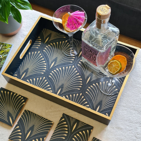 Handcrafted deep blue wooden serving tray decorated with a geometric Art Deco fan design and bronze metallic edging, styled with cocktail glasses and a bottle.