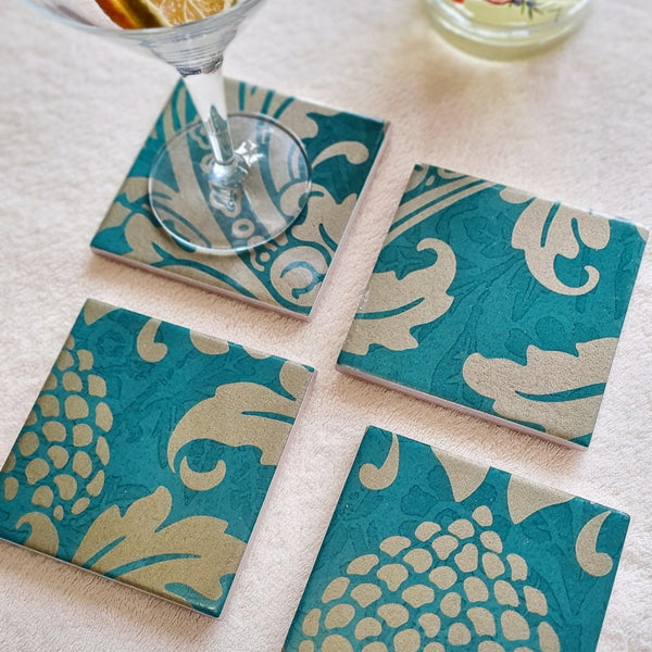 Handcrafted teal ceramic coasters, available separately, decorated with an intricate Baroque-inspired design and metallic Champagne detailing.