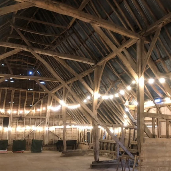 Lit interior of Barn at Manor Farm Bourn Cambridge, hosting Curiosity Fair on Saturday 7 November 2026.