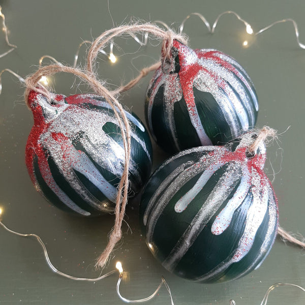 Bespoke green hand-painted Christmas baubles with contrasting drizzle, sparkling glitter