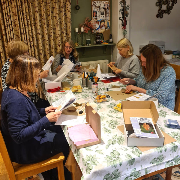 Metal embossing class participants concentrating on the boxed kit and instructions.