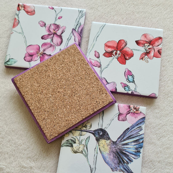Reverse of set of four handmade Hummingbird Floral ceramic coasters with metallic violet edging and cork backing.