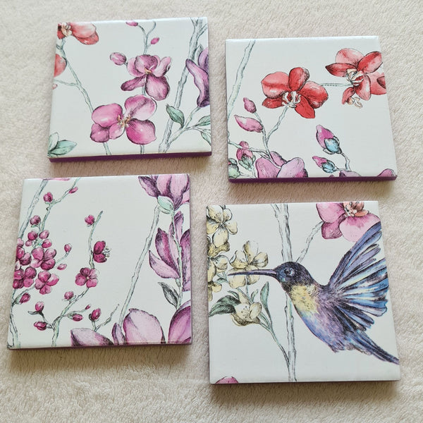 Set of four handmade Hummingbird Floral ceramic coasters with metallic violet edging.