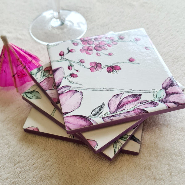 Set of four handmade Hummingbird Floral ceramic coasters stacked with metallic violet edging.