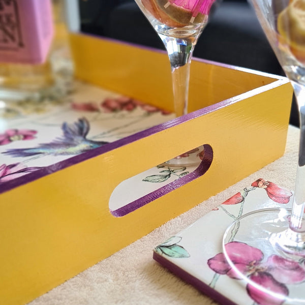 Deep yellow handcrafted wooden serving tray with integrated handles, hummingbird floral design and metallic violet edging.