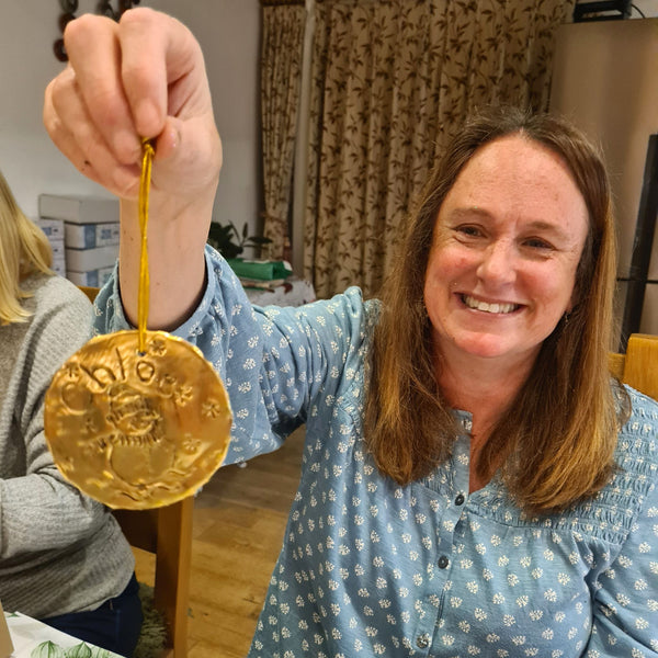 Personalised gold embossed Christmas decoration used as a reusable keepsake gift tag.