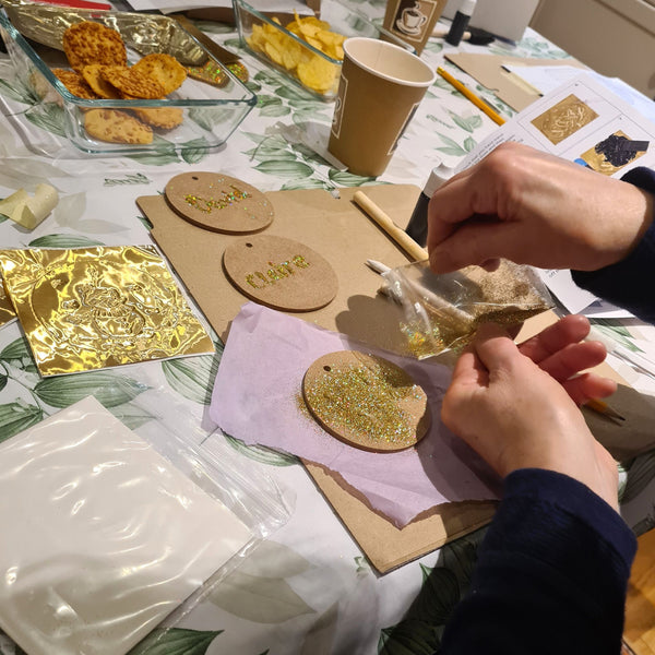 Reverse of a handmade gold Christmas decorations finished with festive glitter.