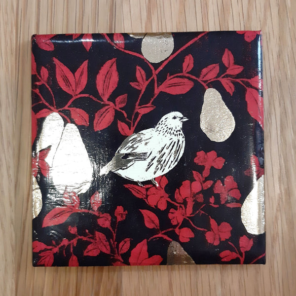 Handmade ceramic coaster featuring a festive Partridge in a Pear Tree design with gold foil detail.