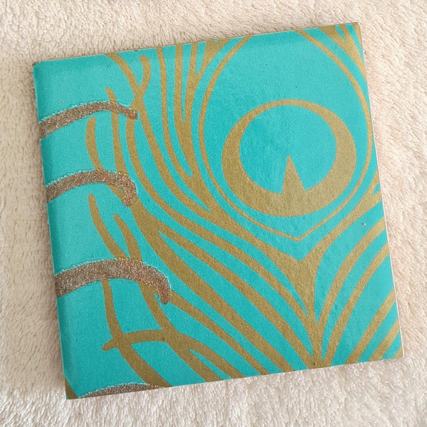 Shimmering metallic design on handmade ceramic coaster.