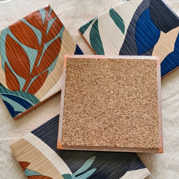 Reverse of limited-edition set of four handmade Retro Leaf ceramic coasters in teal, burnt orange, blue, beige and cream, cork backed.