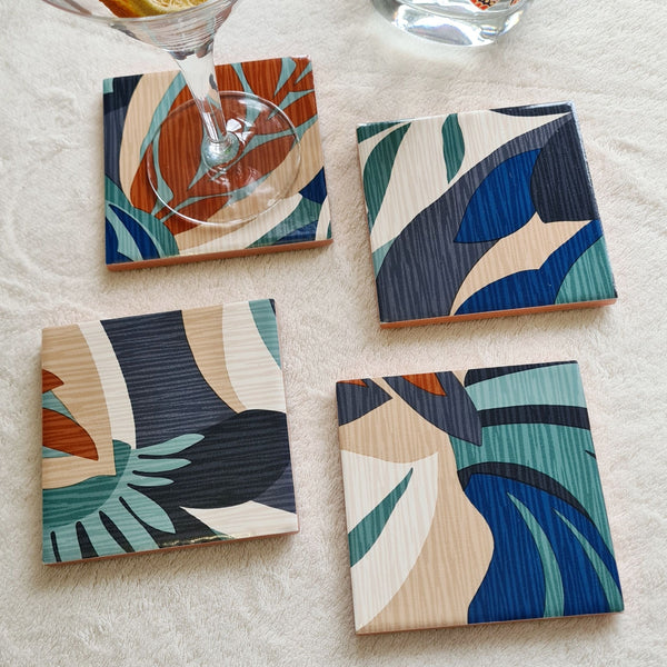 Limited-edition set of four handmade Retro Leaf ceramic coasters in teal, burnt orange, blue, beige and cream.