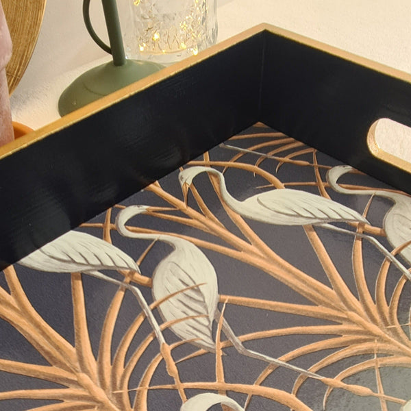 Close view of navy wooden serving tray decorated with Angel Strawbridge Nouveau Heron design and metallic bronze edging.