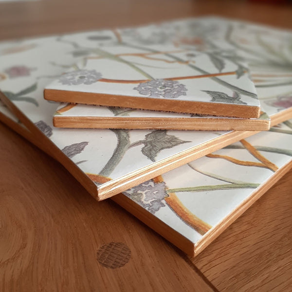 Close-up of hand-painted gold edging on a handmade Chateau Potagerie ceramic placemat and coaster set.