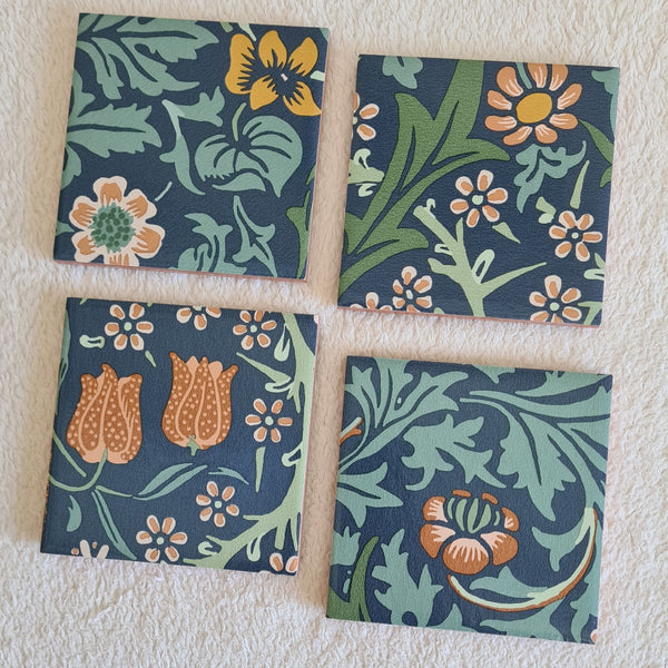 Handmade Blackthorn ceramic coasters in Slate Blue showing flowers, leaves and twisting botanical forms.