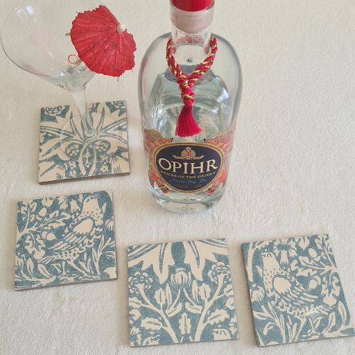 William Morris Brer Rabbit handmade ceramic coasters styled with bottle and cocktail glass with red umbrella.