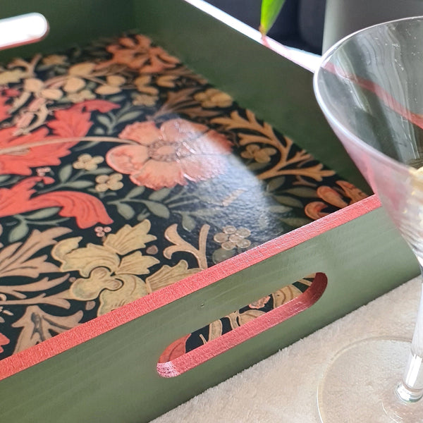 Deep sage green William Morris Compton wooden serving tray with integrated handles and rusty red metallic edging.