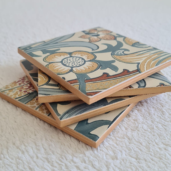Stacked set of four handmade William Morris Golden Lily ceramic coasters in the Slate Blue colourway, showing metallic edges.
