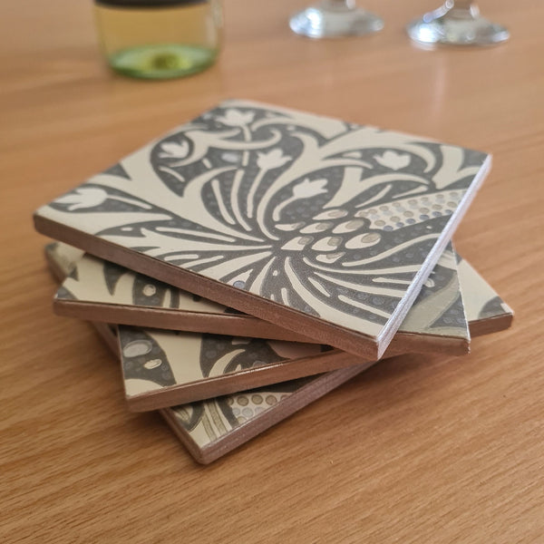Champagne metallic edging on stacked handmade William Morris Seaweed ceramic coasters.