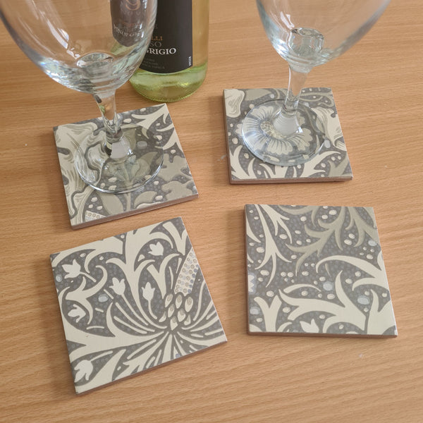 William Morris Seaweed handmade ceramic coasters styled on a coffee table with wine and glasses.