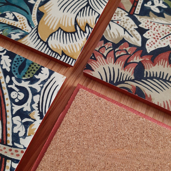 Cork backing on a handmade William Morris Wandle ceramic coaster to help protect furniture, showing rusty red metallic edging.