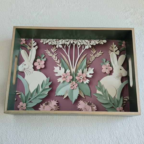 Handcrafted sage green wooden serving tray featuring a symmetrical three-dimensional woodland hare design on a plum background.