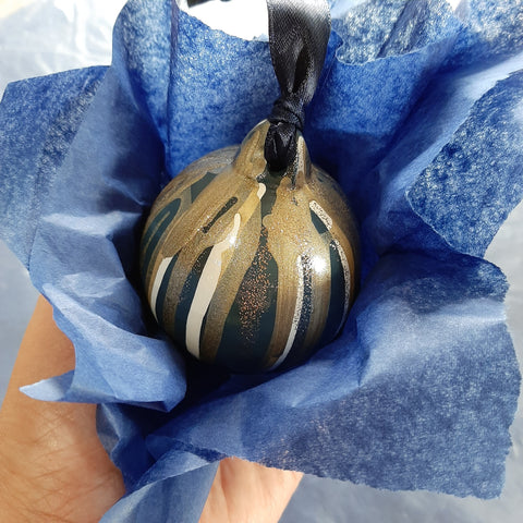 Individual bauble in blue tissue, blue, white, gold and glitter painted bauble, strung with blue ribbon